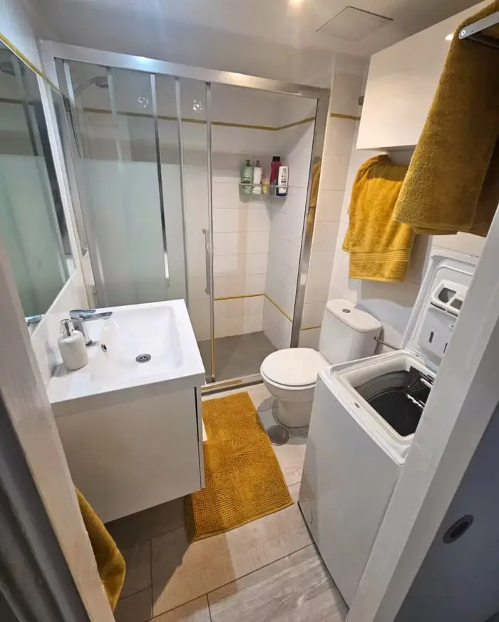 Bad mit großer Glasdusche, Waschbecken und Waschmaschine