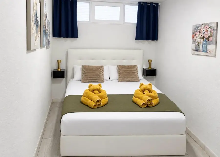 Schlafzimmer mit Doppelbett und zu Teddybären gefalteten Handtüchern