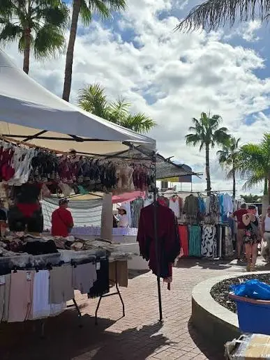 Kleiderstände auf dem Markt unter Palmen